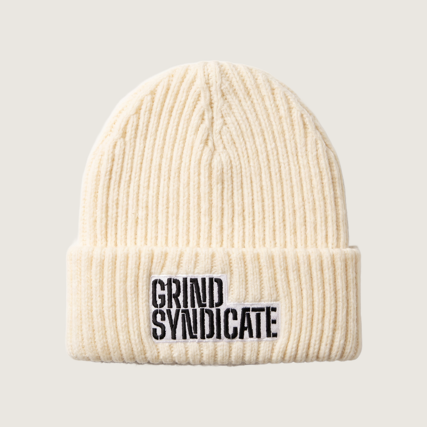 Grind Syndicate beanie in Ivory / Black Logo on a plain bone background