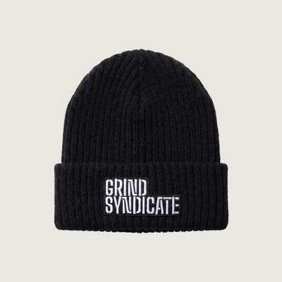 Grind Syndicate beanie in Jet Black / White Logo on a plain bone background